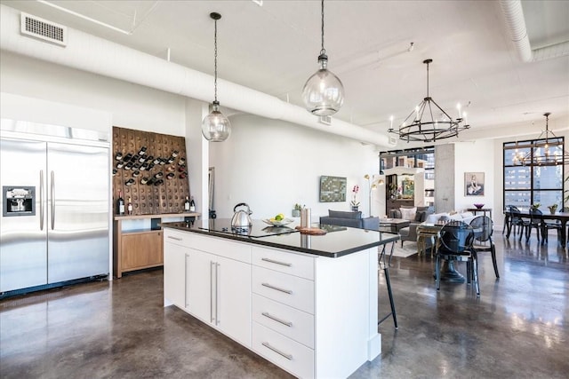 kitchen with pendant lighting, a center island, white cabinetry, black electric stovetop, and stainless steel built in refrigerator