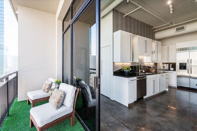 kitchen with appliances with stainless steel finishes, white cabinetry, and sink