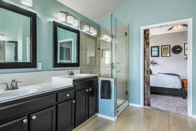 bathroom featuring ceiling fan, a shower with shower door, and vanity