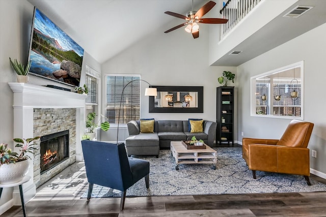 living room with ceiling fan, wood-type flooring, a fireplace, and vaulted ceiling