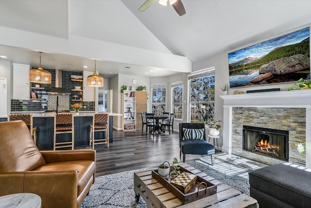 living room with ceiling fan, high vaulted ceiling, a fireplace, and hardwood / wood-style flooring