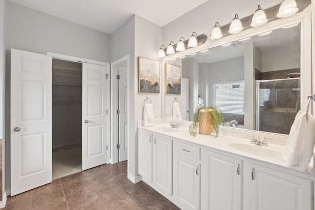 bathroom featuring tile patterned floors, an enclosed shower, and vanity