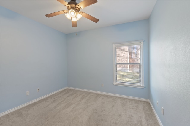 spare room featuring light carpet and ceiling fan