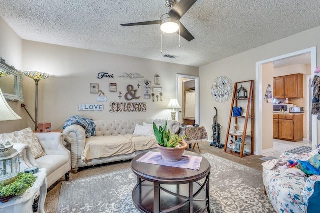 carpeted living room featuring a textured ceiling and ceiling fan