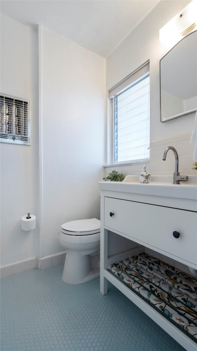 bathroom featuring toilet, tile patterned flooring, backsplash, and vanity