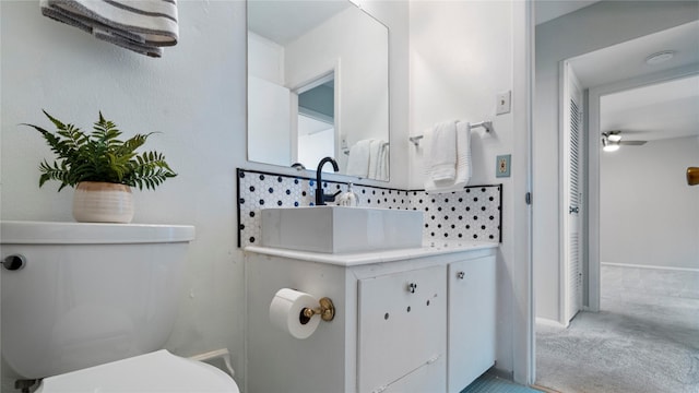 bathroom with toilet, vanity, decorative backsplash, and ceiling fan