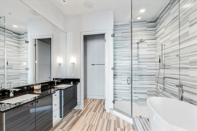 bathroom with tile walls, separate shower and tub, and vanity