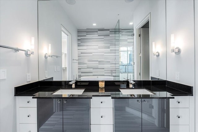 bathroom with a shower with shower door, vanity, and tile walls