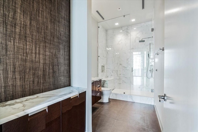 bathroom featuring tile patterned floors, toilet, vanity, and walk in shower