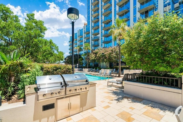 view of patio featuring a grill, a community pool, and area for grilling