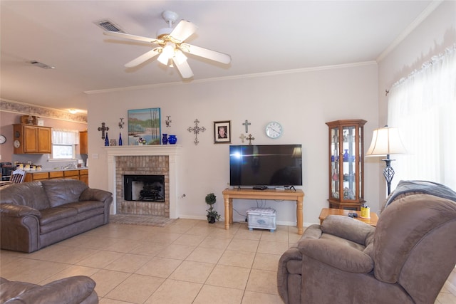 living room with ceiling fan, light tile patterned floors, a brick fireplace, and ornamental molding