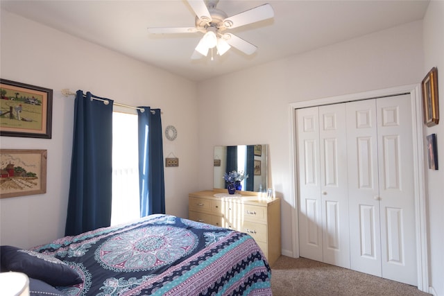 carpeted bedroom featuring ceiling fan and a closet