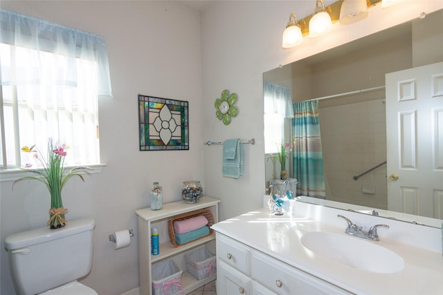 bathroom featuring toilet, vanity, and a shower with curtain