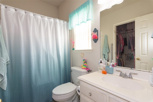 bathroom featuring toilet, vanity, and walk in shower