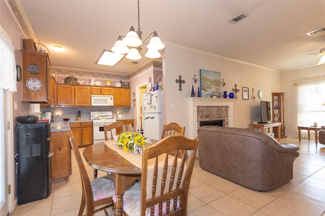 dining space featuring light tile patterned floors, a brick fireplace, and crown molding