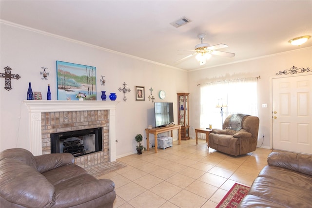 living room featuring a fireplace, ceiling fan, light tile patterned flooring, and ornamental molding