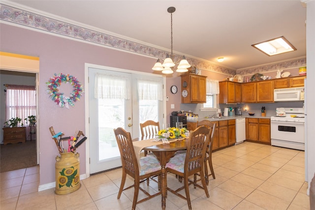 dining area with light tile patterned floors, ornamental molding, french doors, a chandelier, and sink