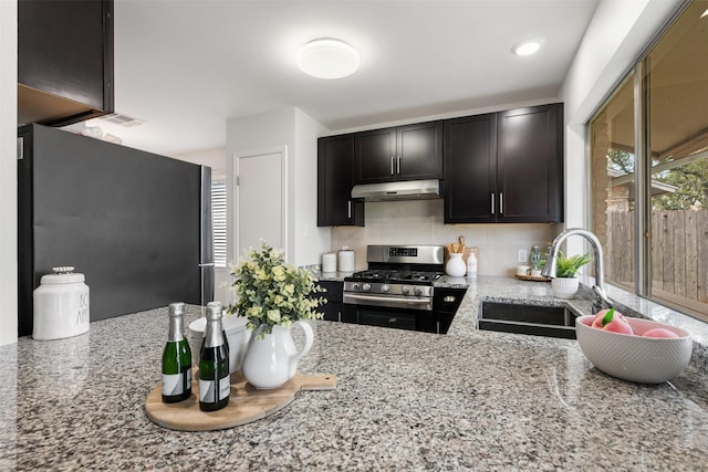 kitchen featuring light stone countertops, a healthy amount of sunlight, appliances with stainless steel finishes, and sink