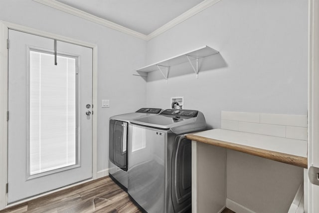 washroom with dark hardwood / wood-style flooring, crown molding, and washing machine and clothes dryer