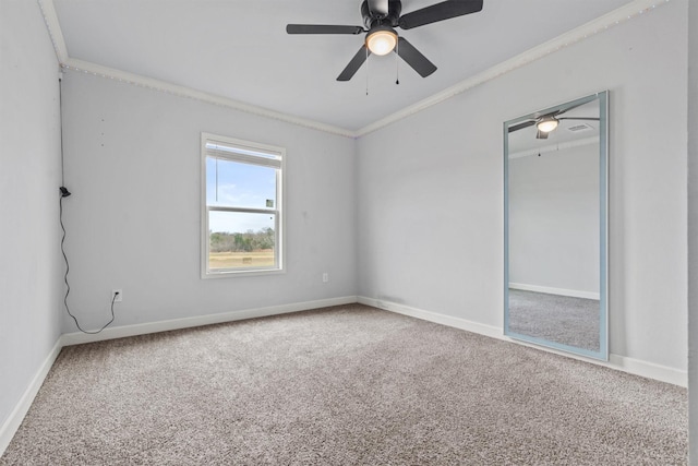 unfurnished room featuring ceiling fan, crown molding, and carpet flooring