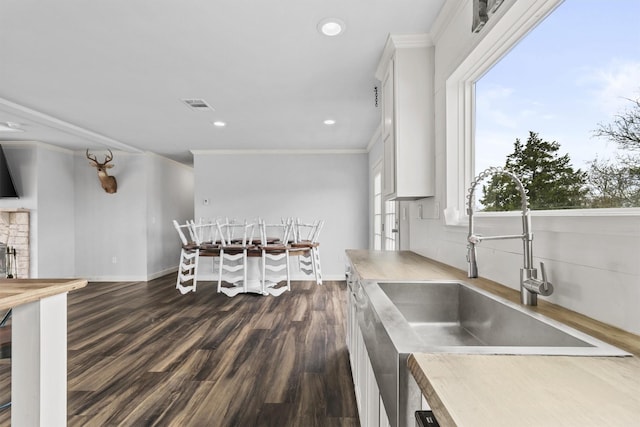 kitchen featuring dark hardwood / wood-style floors, sink, crown molding, and white cabinetry