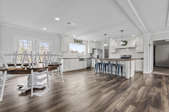 kitchen with white cabinetry, pendant lighting, stainless steel appliances, and a center island