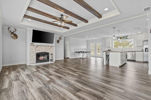 unfurnished living room with ceiling fan, ornamental molding, a fireplace, and wood-type flooring