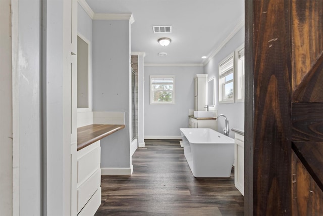 bathroom featuring vanity, independent shower and bath, crown molding, and hardwood / wood-style floors