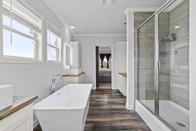 bathroom with independent shower and bath, crown molding, wood-type flooring, and vanity