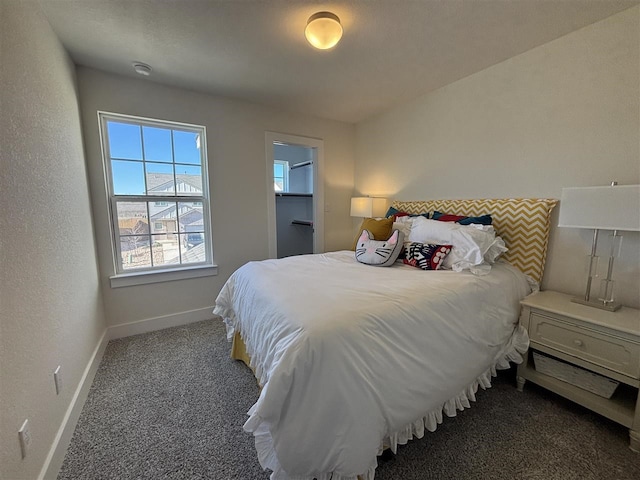 bedroom featuring a spacious closet and dark carpet