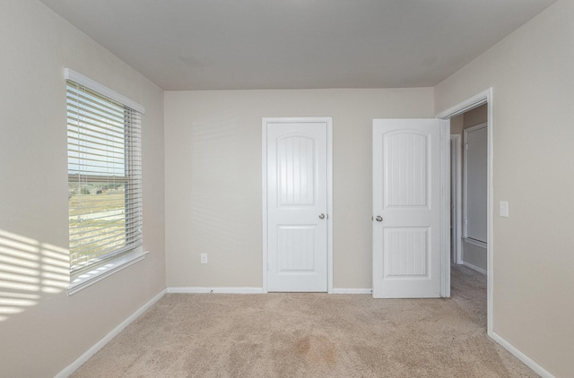 unfurnished bedroom with light colored carpet