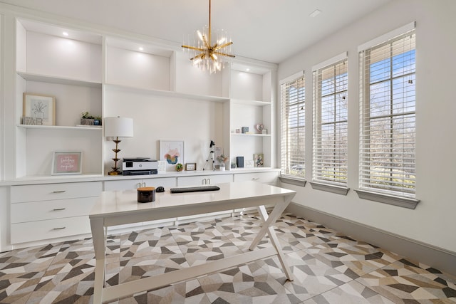 office space featuring built in shelves, an inviting chandelier, and a healthy amount of sunlight