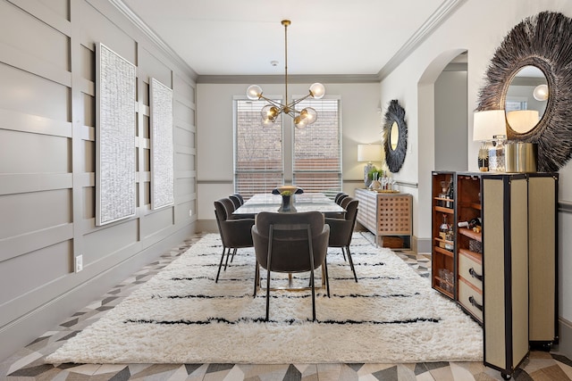 dining space featuring a notable chandelier, ornamental molding, and built in shelves