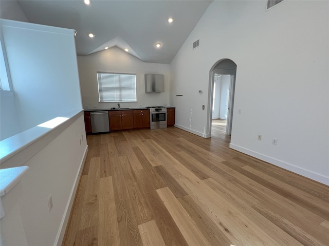 unfurnished living room featuring high vaulted ceiling, light wood-type flooring, and sink