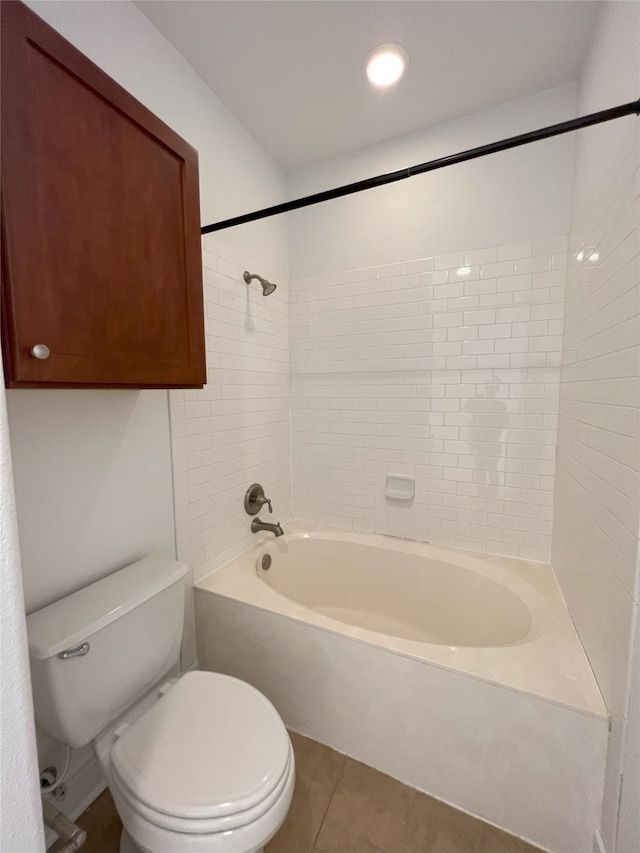 bathroom with toilet, tiled shower / bath, and tile patterned flooring