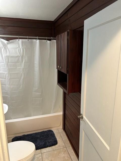 bathroom featuring toilet, shower / bath combination with curtain, and tile patterned floors