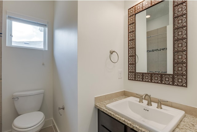 bathroom with toilet, vanity, and tile patterned flooring