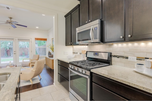 kitchen with ceiling fan, appliances with stainless steel finishes, decorative backsplash, and light stone counters