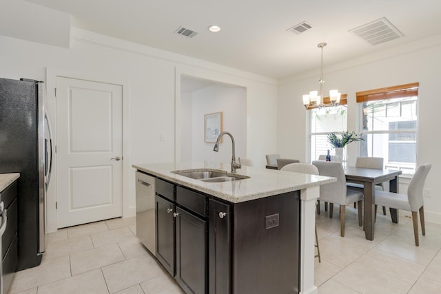 kitchen featuring pendant lighting, sink, an island with sink, stainless steel appliances, and a chandelier