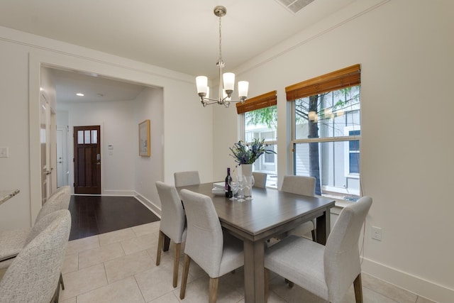 tiled dining room featuring ornamental molding and a notable chandelier