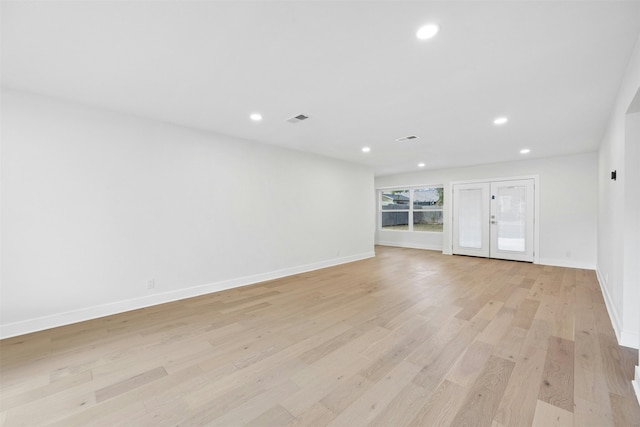 spare room featuring light wood-type flooring and french doors