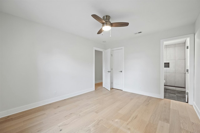 unfurnished bedroom featuring ensuite bath, ceiling fan, and light hardwood / wood-style floors