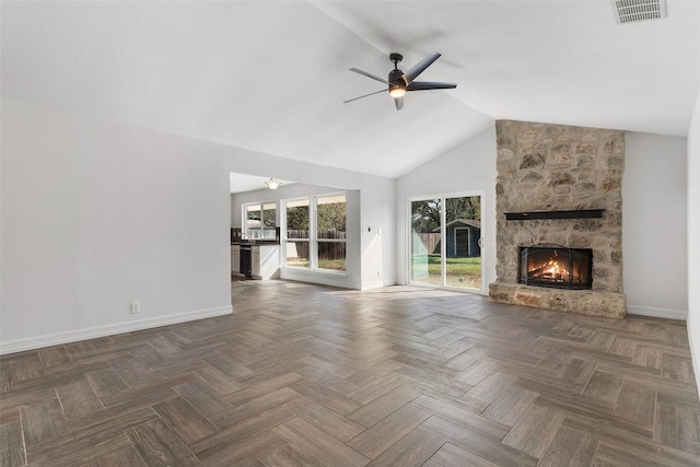 unfurnished living room with ceiling fan, dark parquet flooring, lofted ceiling, and a fireplace