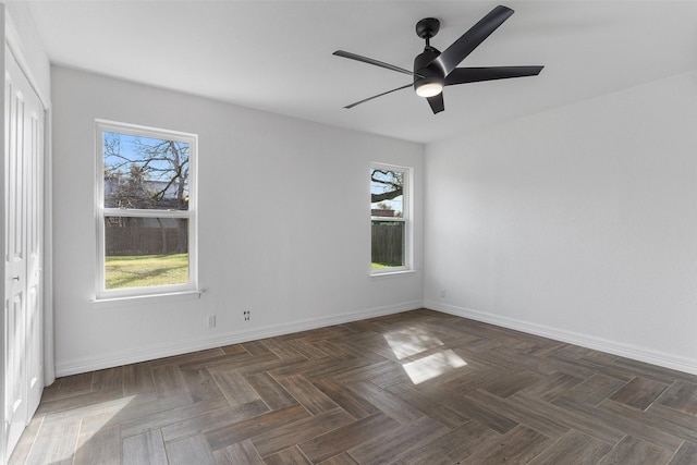 spare room with ceiling fan and dark parquet floors