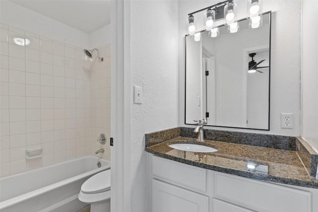 full bathroom featuring toilet, ceiling fan, tiled shower / bath combo, and vanity