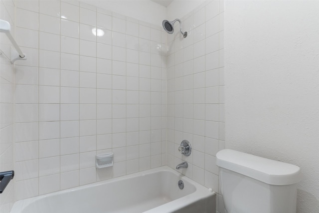 bathroom with toilet and tiled shower / bath combo