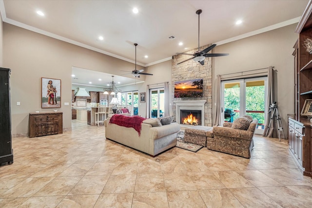 living room featuring ceiling fan, crown molding, and a stone fireplace