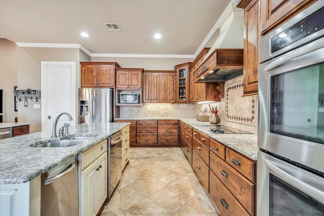 kitchen with appliances with stainless steel finishes, backsplash, a kitchen island with sink, ornamental molding, and sink