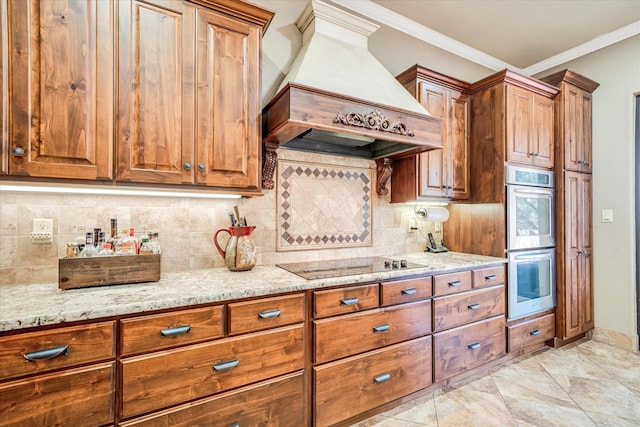 kitchen featuring black electric stovetop, custom exhaust hood, decorative backsplash, light stone countertops, and double oven