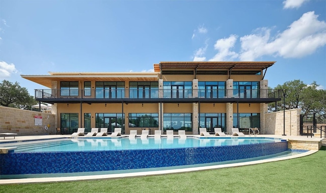 back of property with stucco siding, a patio, and a community pool